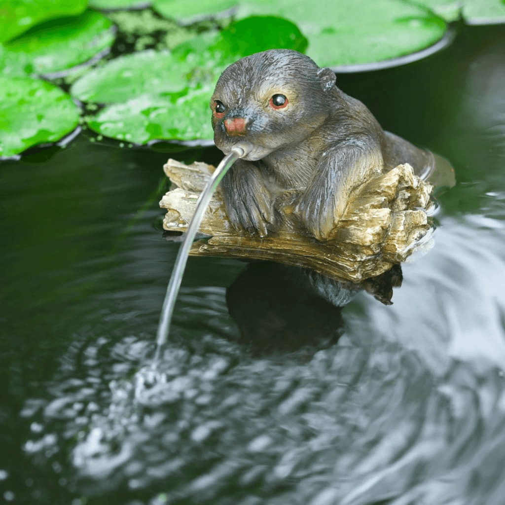 Ubbink Floating Spitter Garden Fountain Otter, Enhance your pond with the elegant, weather-resistant Ubbink Otter Garden Fountain. Features a captivating otter on a tree trunk.